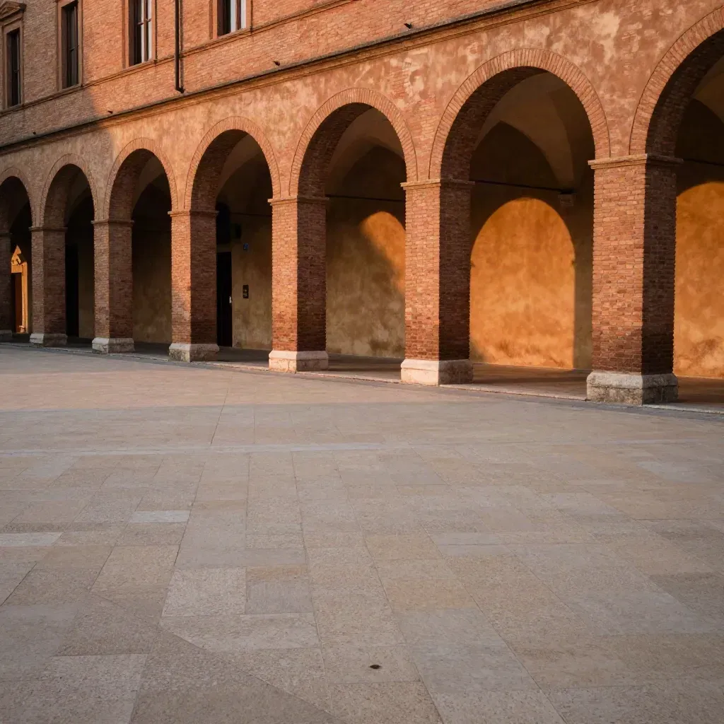 Portici di Emilia-Romagna al tramonto con piazza vuota e luce calda.